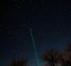 Green laser pointing to a star